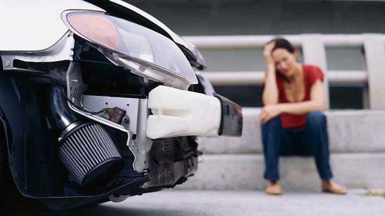 Upset woman near her car after an accident.